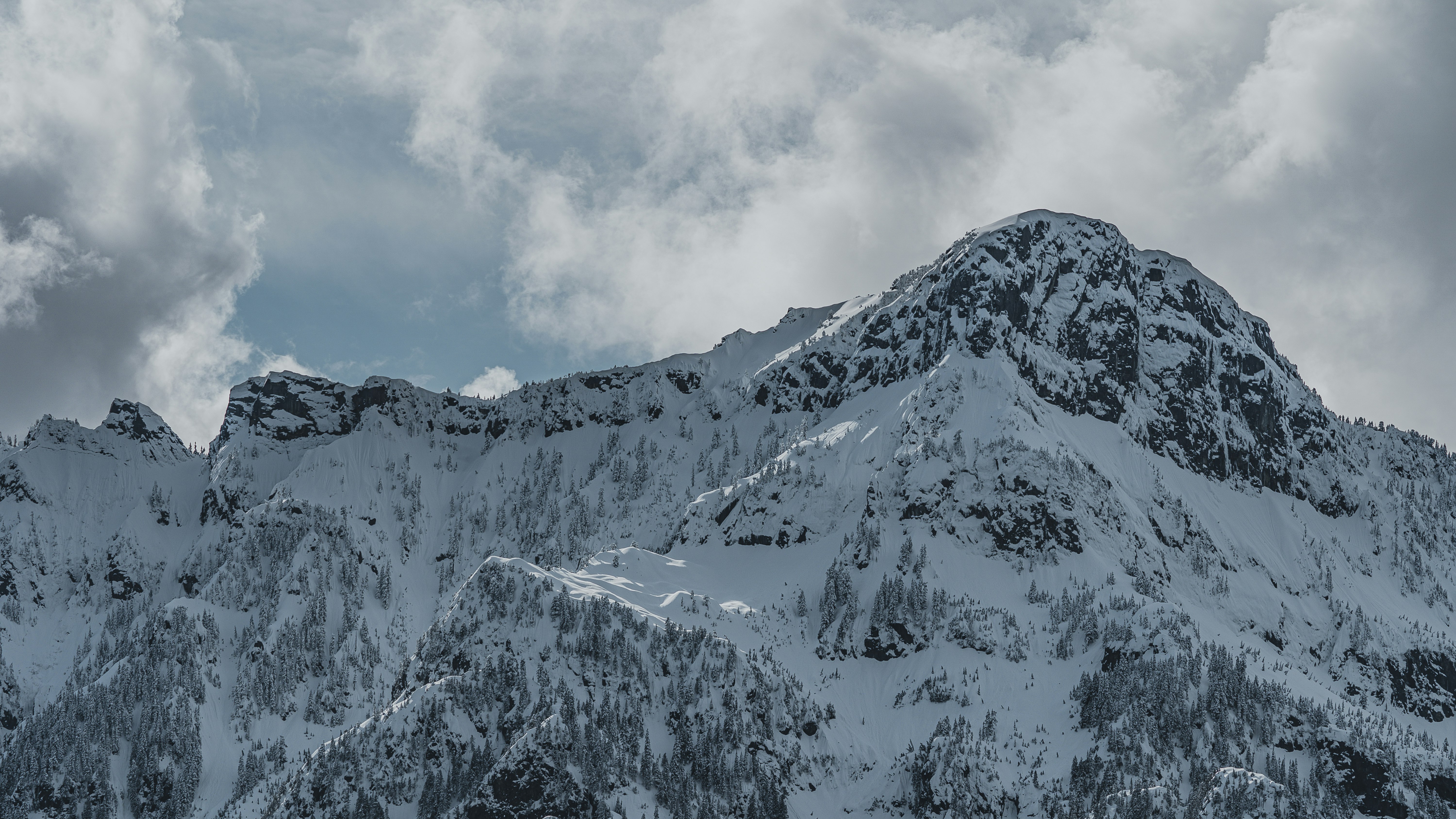 snow covered mountain under cloudy sky during daytime